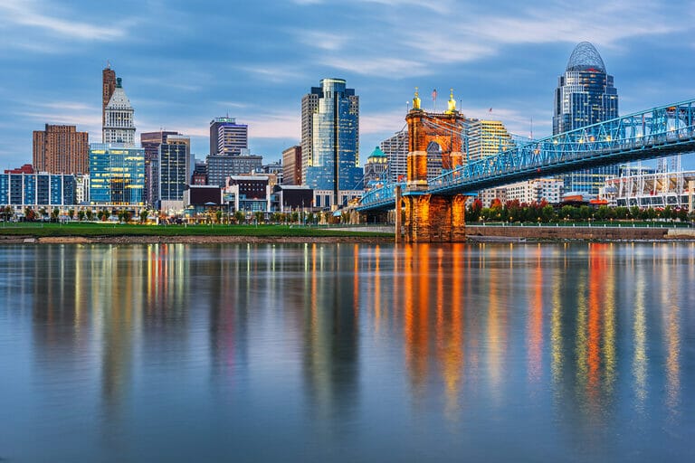 Cincinnati, Ohio downtown skyline and bridge on the river at dusk.